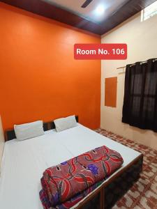 a room with a bed with a sign that reads room no at Agrawal guest house in Ujjain