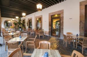 Hotel Casino Morelia في موريليا: مطعم فيه طاولات وكراسي في الغرفة
