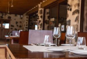 een tafel met drie wijnglazen en borden erop bij Hotel Rural El Cabo de "Casa Marcos" in Villaverde