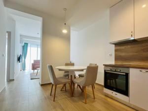 a kitchen and dining room with a table and chairs at Rafailovici Beachfront Apartment in Budva