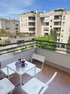 una mesa blanca y sillas en un balcón con edificios en Astri Apartment, en Roma
