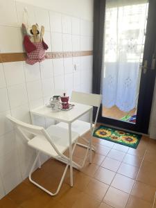 Una mesa blanca y una silla en una habitación con ventana en Astri Apartment, en Roma