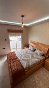 ein Schlafzimmer mit einem Bett und einem großen Fenster in der Unterkunft Lapatchi appart in Agadir