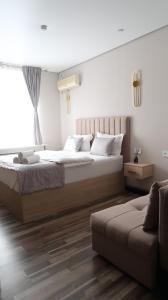 a bedroom with two beds and a couch at AG Hotel Nazarbaeva in Almaty