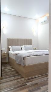um quarto com uma cama grande e lençóis brancos em AG Hotel Nazarbaeva em Almaty