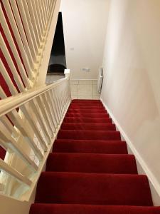 ein Treppenhaus mit rotem Teppichboden und ein Treppenhaus in der Unterkunft Caroline Court House in Burton upon Trent