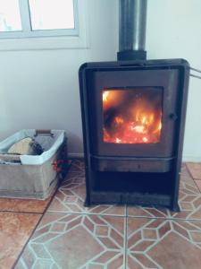 a woodburning stove in a room with a dog crate at Casa Valle Volcanes in Puerto Montt