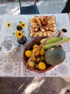 um cesto de frutas e produtos hortícolas sobre uma mesa em Guest house Nano em Martvili
