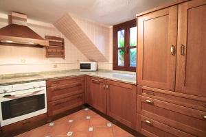 a kitchen with wooden cabinets and a microwave at La Casita de la Plaza - ONLY ADULTS by SIERRA VIVA in Aracena
