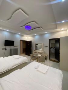 Cette chambre comprend 2 lits et une télévision. dans l'établissement Viola desert, à Al-Ula