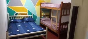 a room with two bunk beds and a wall with a mural at Tu Hostel Tucuman in San Miguel de Tucumán