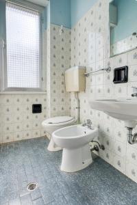 a bathroom with a white toilet and a sink at Hotel Sabbia d'Oro in Rimini