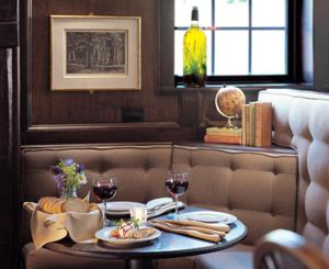 un tavolo con due bicchieri di vino e cibo sopra di Green Mountain Inn a Stowe