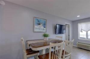 a dining room with a table and a tv at Oceanfront Condo with Pool and Hot Tub! in Virginia Beach