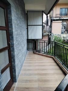 een balkon met een houten vloer en een bakstenen muur bij Galaxy Inn Homestay in Banikhet