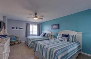 two beds in a bedroom with blue walls at Oceanfront Condo with Pool and Hot Tub! in Virginia Beach