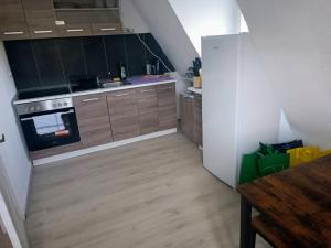 a small kitchen with wooden cabinets and a refrigerator at Monteurwohnung - Worker's apartment - Pforzheim Belremstraße in Pforzheim +18 photos