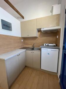 una pequeña cocina con armarios blancos y fregadero en KROISSOS en Galissas