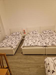 a room with two beds and a table at Sobe - Nova Gradiška smještaj Auto Klarić in Nova Gradiška