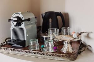 a tray with a toaster and glasses on a counter at Villa Paradiso Charme&Design in Arquata Scrivia