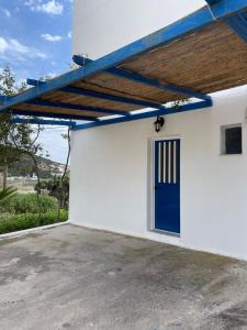 un garaje con una puerta azul en un edificio blanco en KROISSOS, en Galissas 13 fotos más