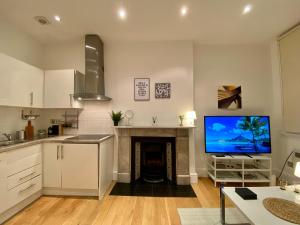 a kitchen with a living room with a fireplace and a tv at One-bed flat Central London Payment required STRAIGHT away The host will message you after you've made a reservation in London