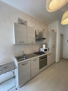a kitchen with white cabinets and a sink at Casa Lorizia in Pietra Ligure