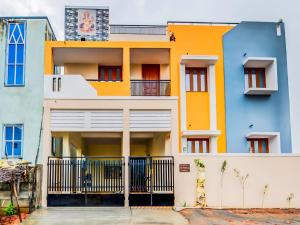 a colorful house with a fence in front of it at SAI BALAVANY RESIDENCY Pondicherry in Puducherry