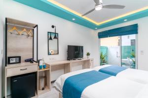 a bedroom with a bed and a tv in it at Ukulhas Sands in Ukulhas
