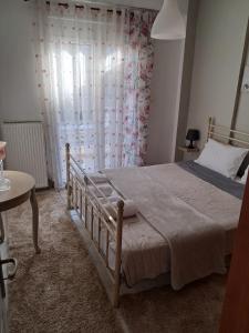 Schlafzimmer mit einem Bett, einem Tisch und einem Fenster in der Unterkunft M home place in Palio Limani