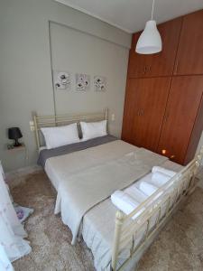 1 dormitorio con 1 cama blanca y armario de madera en M home place, en Palio Limani