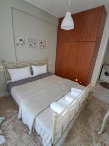 sypialnia z białym łóżkiem i drewnianą szafką w obiekcie M home place w mieście Palio Limani