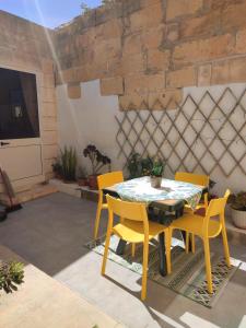 a patio with a table and yellow chairs at Charming House in Victoria, Gozo in Victoria