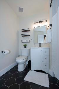 a bathroom with a white toilet and a mirror at Cozy Studio Apt Close to the Gardens - King Bed in Huntsville