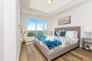 a bedroom with a bed and a large window at Newly Built Condo w Amazing Amenities and Views in Kitchener