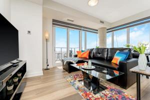 a living room with a black leather couch and a table at Newly Built Condo w Amazing Amenities and Views in Kitchener