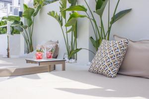 um sofá com uma almofada e uma mesa com plantas em Ampelia Hotel Kassandra em Chaniotis