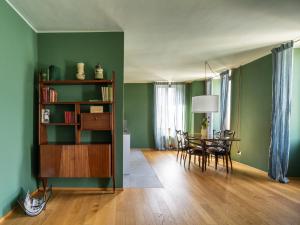 salon z zielonymi ścianami, stołem i krzesłami w obiekcie Domus Plinii 1792 Suites w mieście Faggeto Lario 