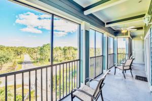 balcón con 2 sillas y vistas al agua en Upscale 3BR Near Disney - Pool and Hot Tub!, en Orlando