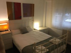 a small bedroom with a bed with white sheets at Apartamento Manuela Sancho in Zaragoza