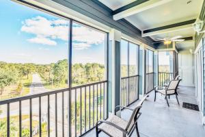 einen Balkon mit 2 Stühlen und einem großen Fenster in der Unterkunft Spacious 3BR Near Disney - Pool and Hot Tub! in Orlando