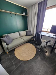 a living room with a couch and a desk at CityStation 59m2 Top Floor Sauna Apartment, WiFi in Lahti