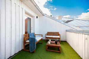 Un pequeño balcón con 2 sillas y una mesa. en Luxury 2-floor apartment with sauna and balcony en Tallin