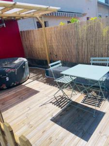 una mesa de picnic en una terraza con una valla en Cosy, 2min Gare, work fun jacuzzi en juin, en Bellegarde-sur-Valserine