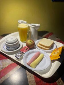 - un plateau avec un hot-dog, du pain et du jus d'orange dans l'établissement lux motel, à Holambra