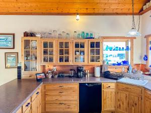 a kitchen with wooden cabinets and a black dishwasher at The Shepherd's Retreat in Livingston