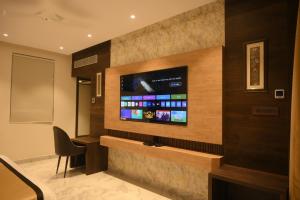 Habitación de hotel con TV de pantalla plana en la pared en Hotel The Plateau en Ranchi