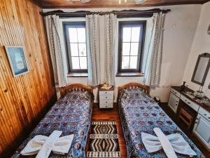 a bedroom with two beds and two windows at Orman İçinde Muhteşem Villa in Kayakoy