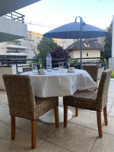 a table and chairs with a table and an umbrella at Au Clos Celestin in Annemasse