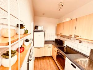 uma cozinha com electrodomésticos brancos e armários de madeira em 2-Zimmer Wohnung in Bremen-Vahr em Bremen
